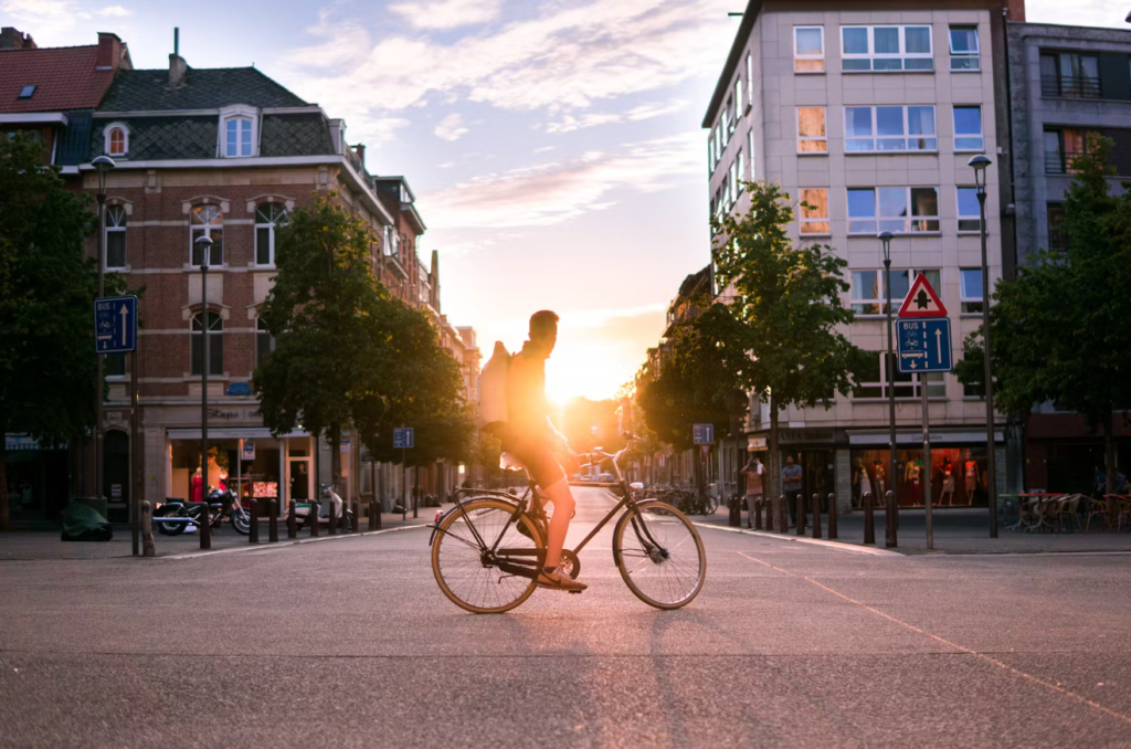 Un cycliste paisiblement arrêté en ville, admirant le coucher du soleil