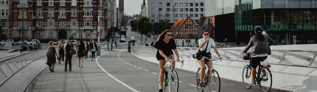 Deux femmes qui font du vélo parmi d'autres cyclistes et piétons