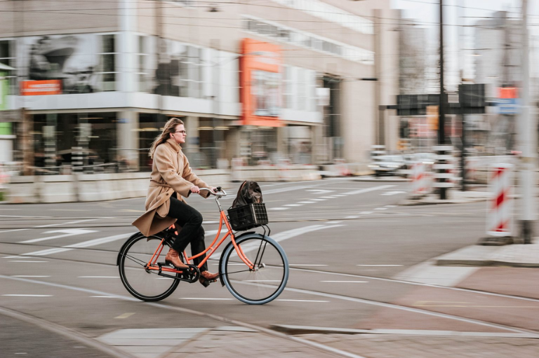 Une femme sur un vélo orange en ville