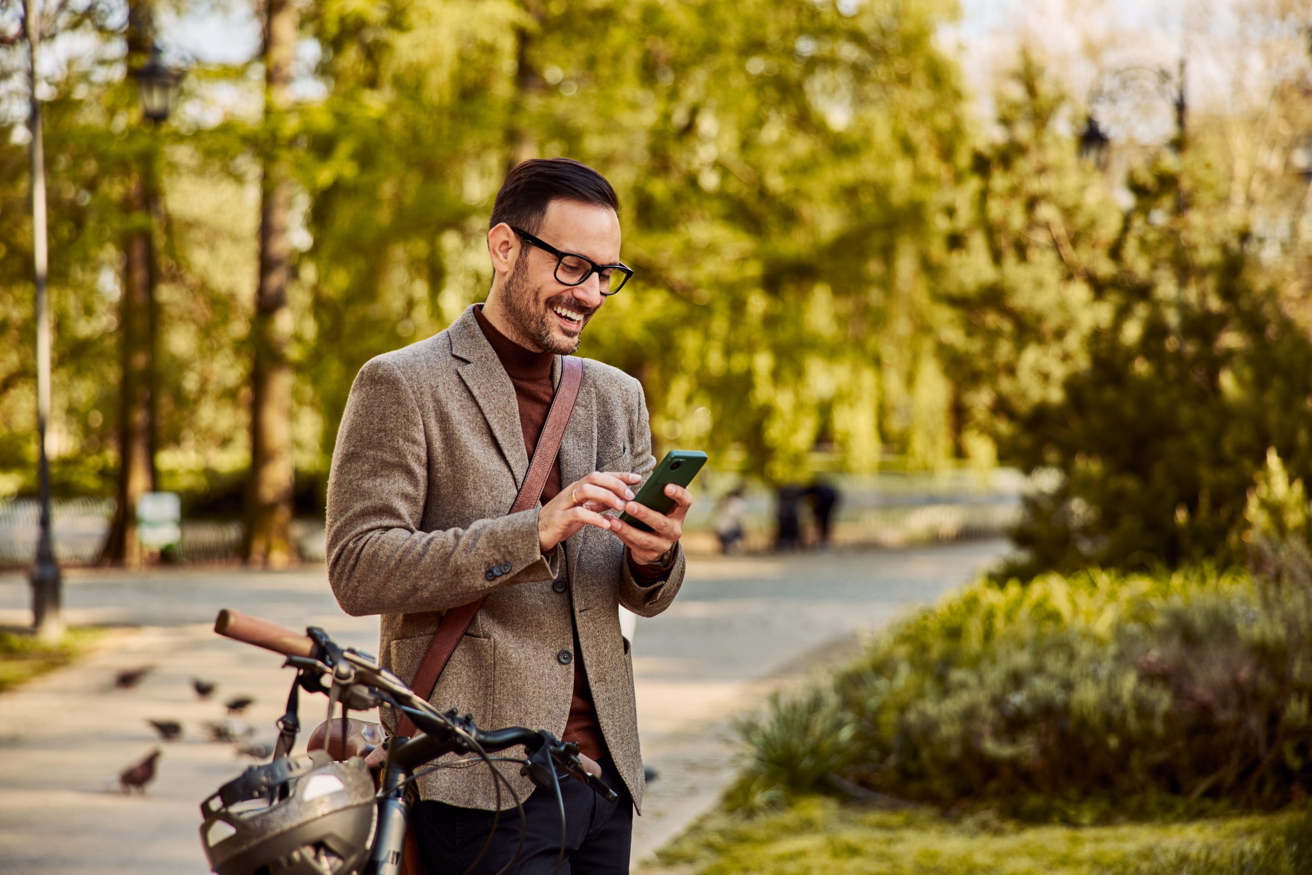 Un salarié vélotaffeur qui consulte son téléphone à l'extérieur