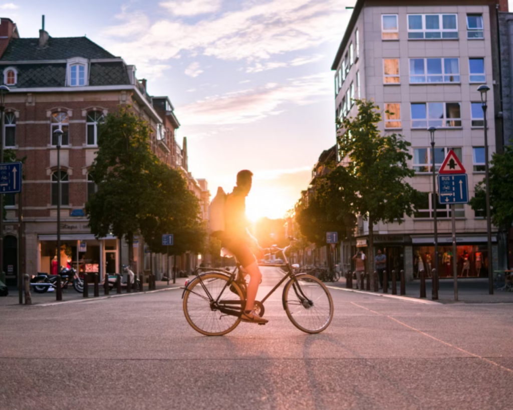 Un cycliste paisiblement arrêté en ville, admirant le coucher du soleil