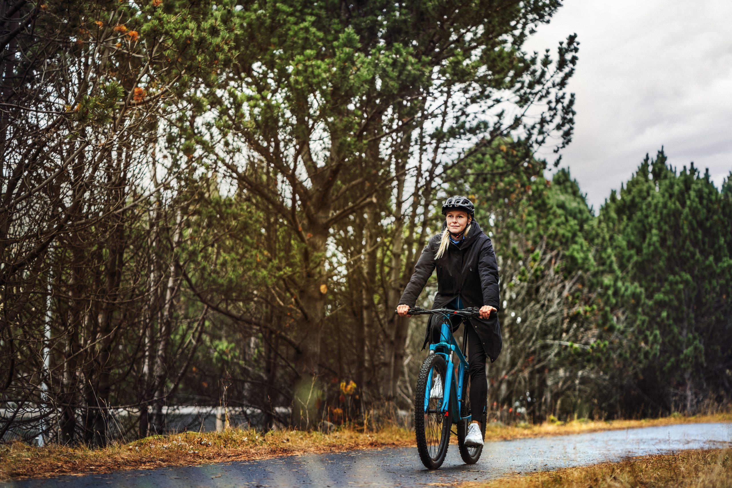 Une femme à vélo en forêt qui se rend au travail