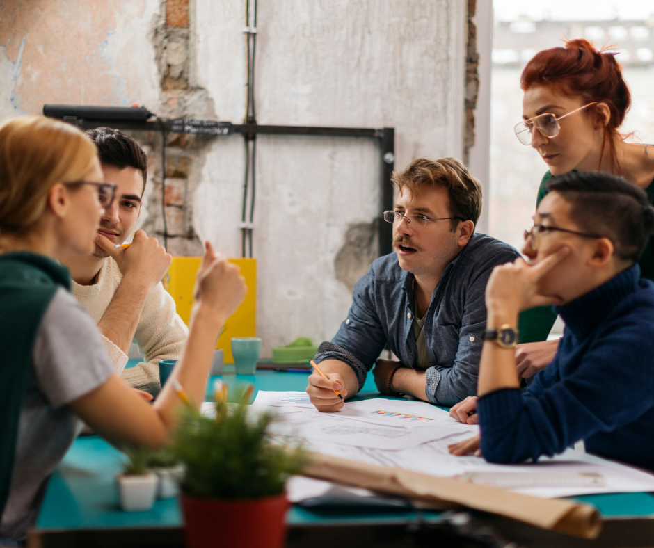 Un groupe de collaborateurs qui discutent autour d'une table